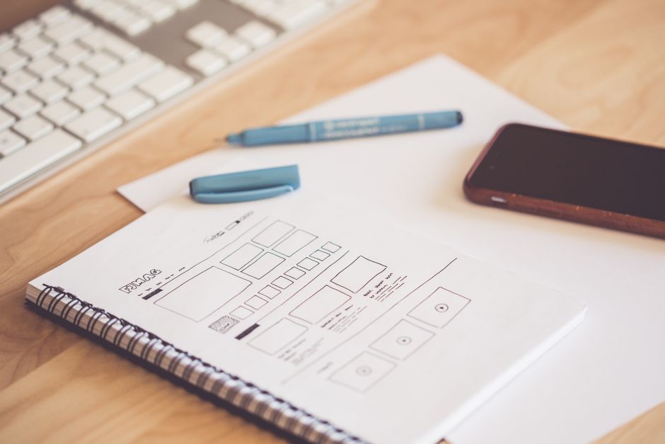 Hand-drawn app wireframes in a notebook