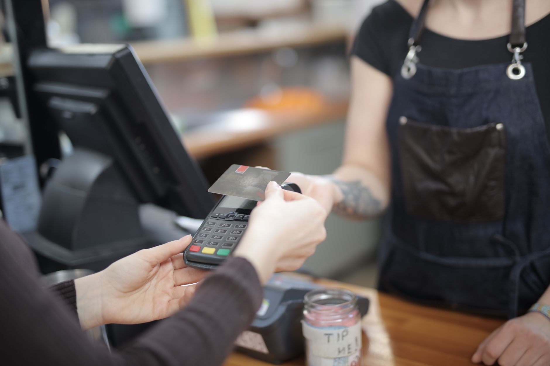 A customer paying by card at a counter
