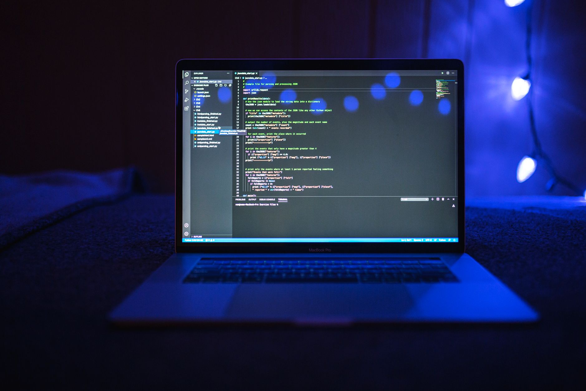 A laptop showing code in a dark room